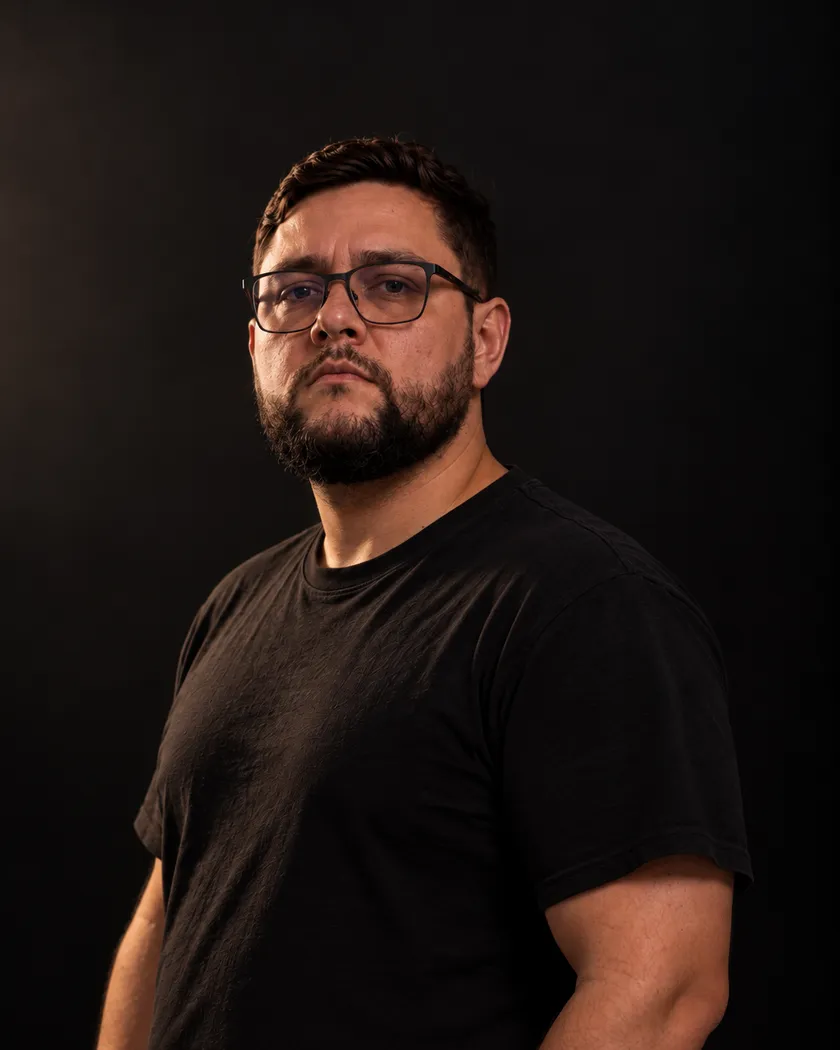 Antônio Miranda, de camiseta preta, em retrato sobre fundo escuro